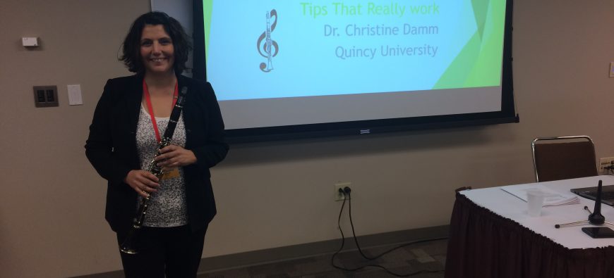 Christine Damm poses with clarinet at a seminar she presented at.