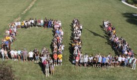 Students on Friars Field making the letters QU