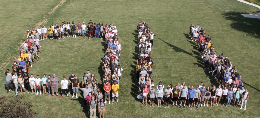 Students on Friars Field making the letters QU