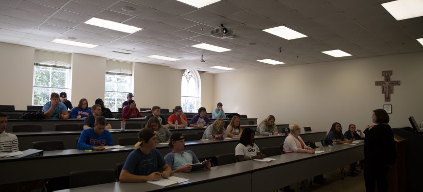 Students sitting in a classroom listening to their professor.