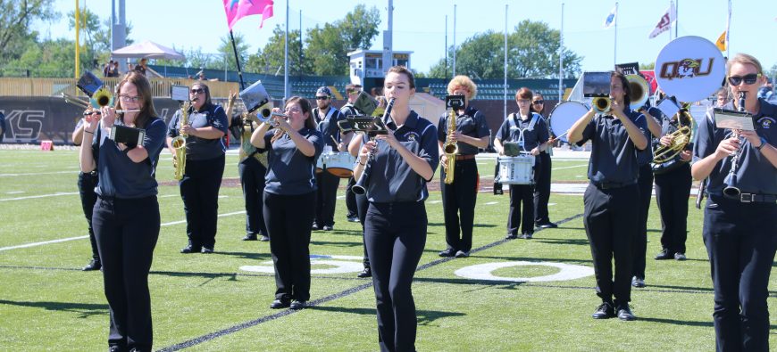 Some students performing in the band on the football field