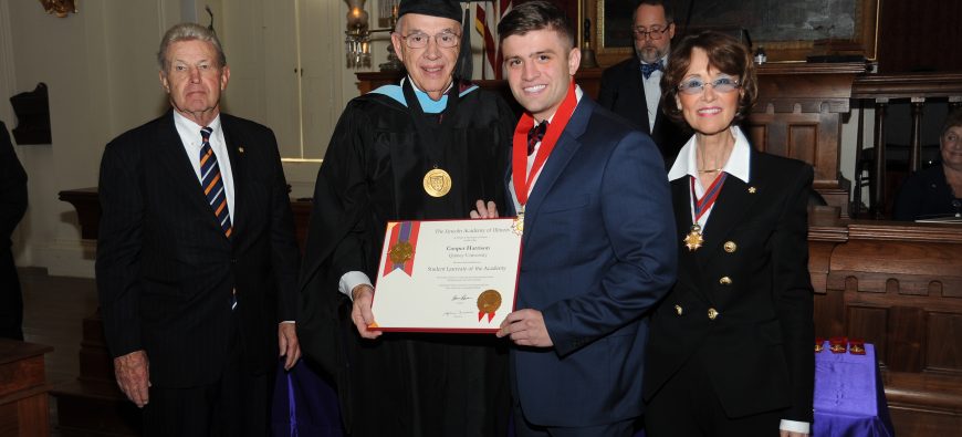 Two men holding an award with a woman