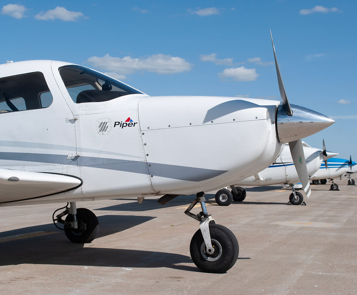 Close up of plane on runway parked in a row of planes