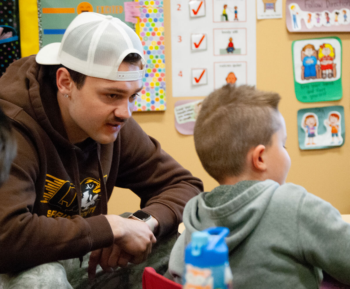 Student working with child in classroom