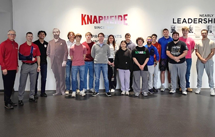group of students infront of a knapheide sign during a class visit.