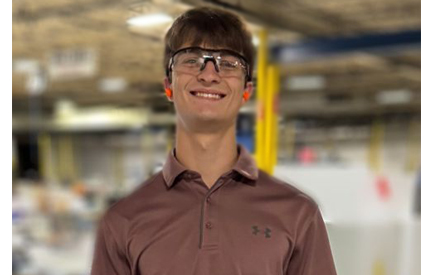 male student with safety glasses on in a factory