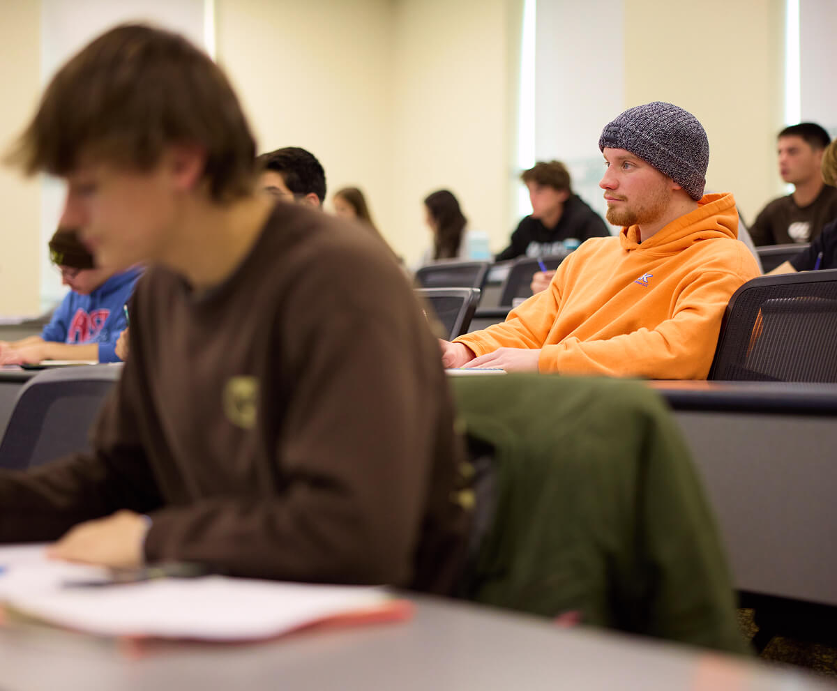 Classroom full of students listening and taking notes during lecture