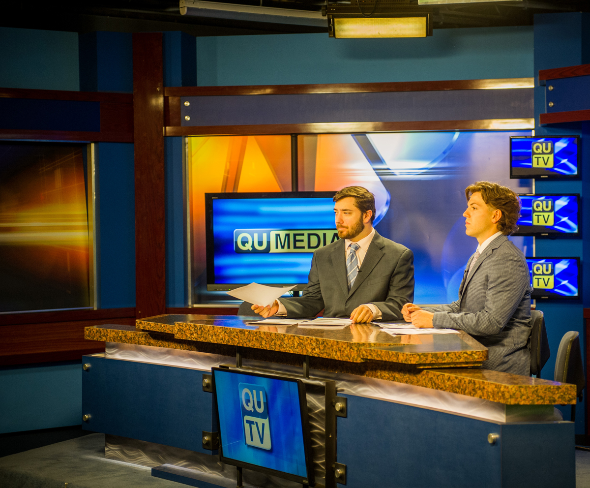 Communication students sitting at QUTV news desk