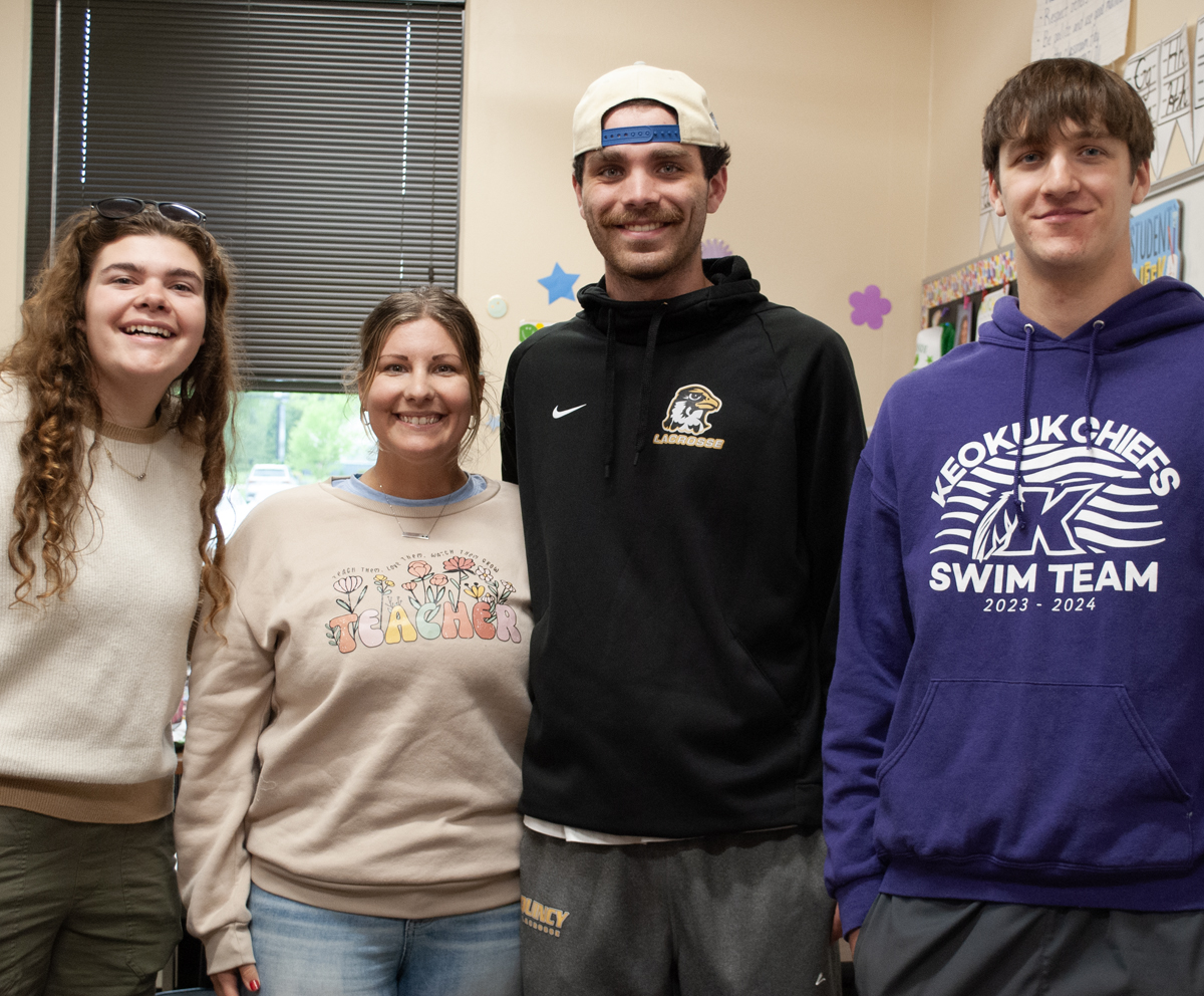 Education majors standing with Education Alumn in a classroom