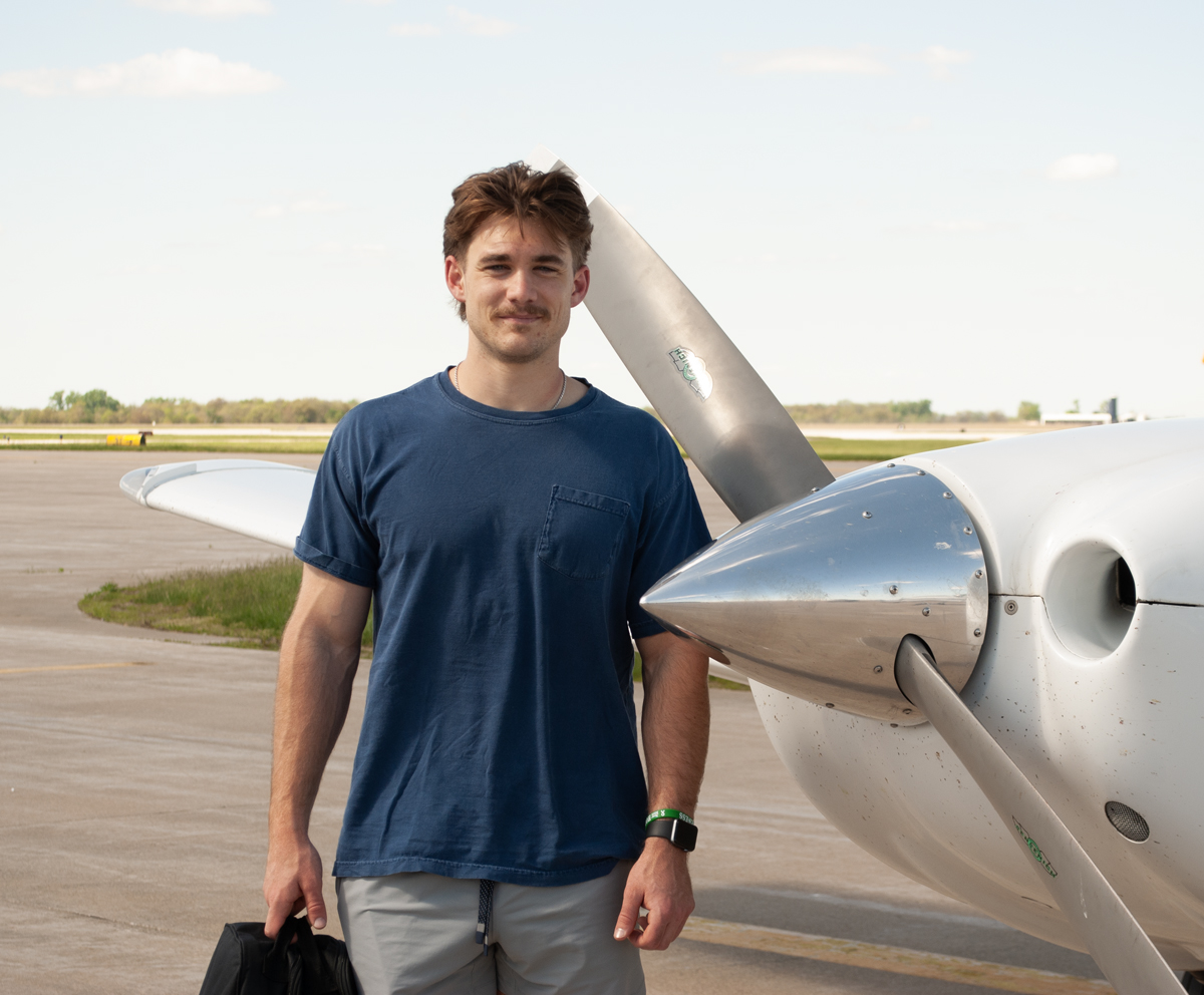 Aviation student standing next to plane