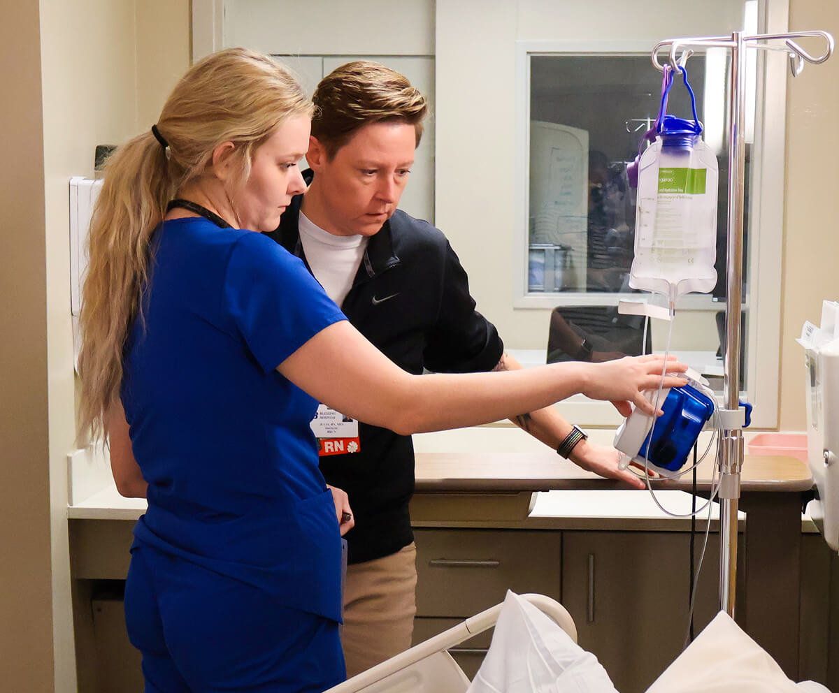 Nursing student training with professor on patient monitoring equipment