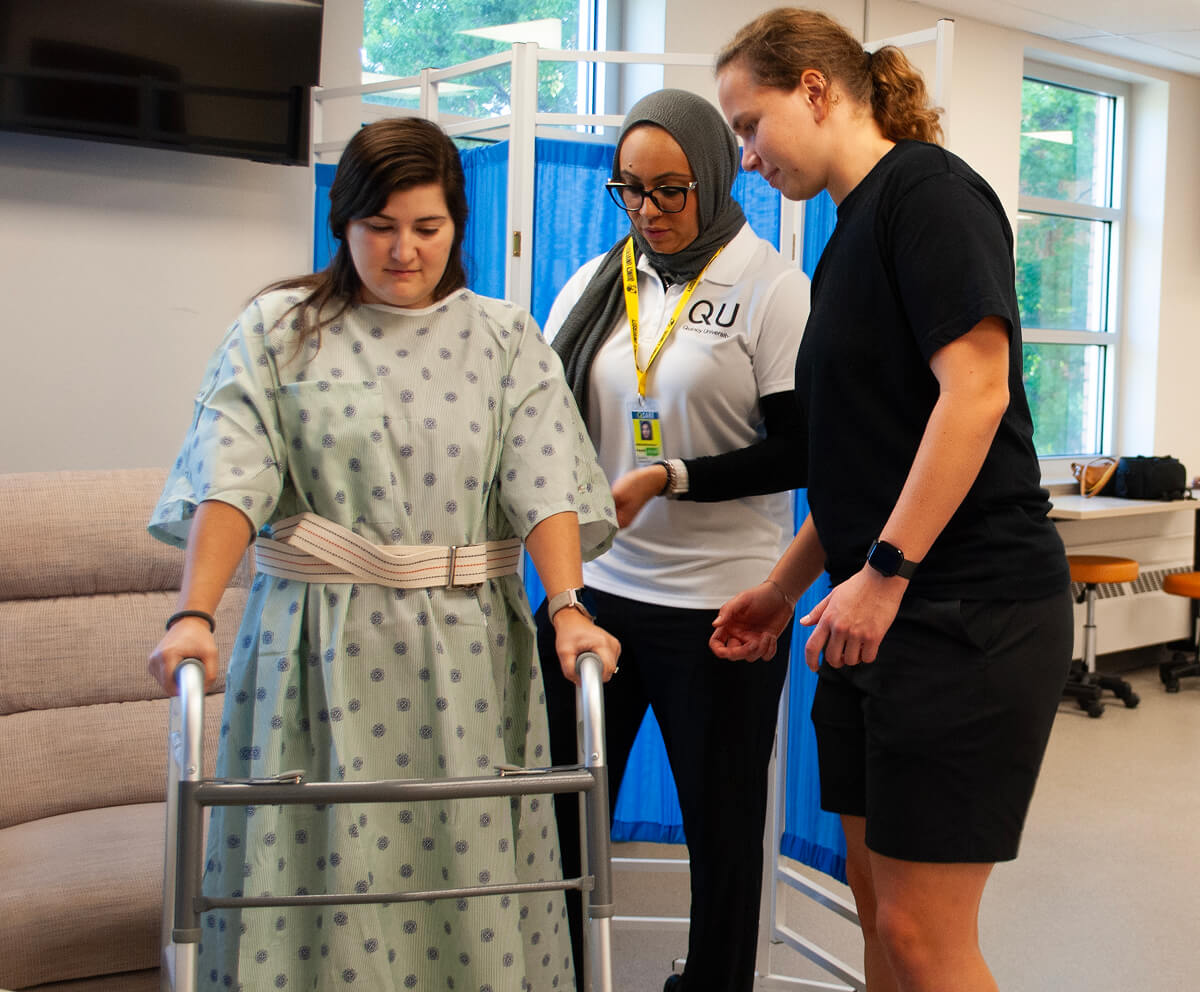 Students training with occupational therapy professor with walker