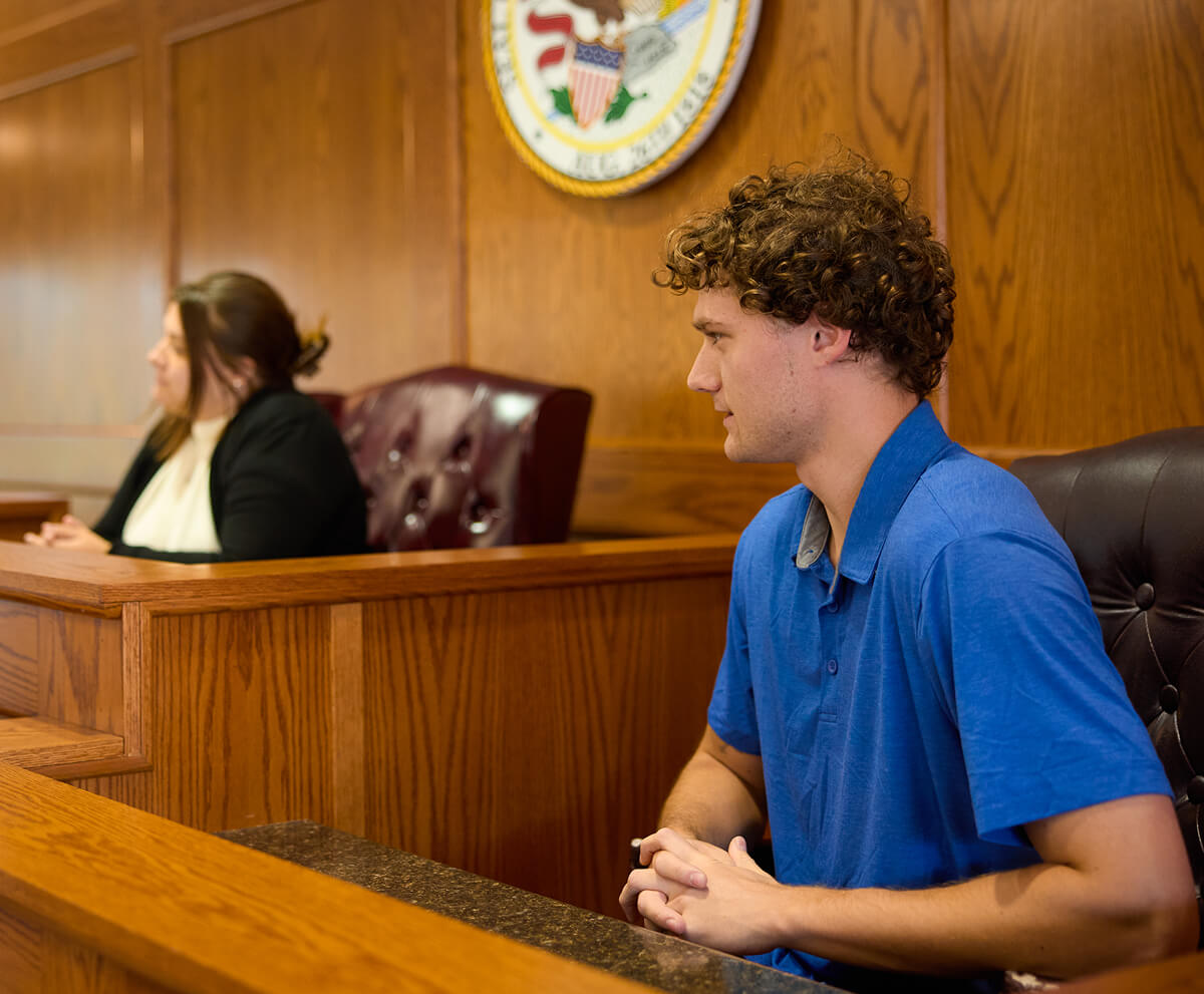 Students sitting in judges chair and witness stand during a mock trial