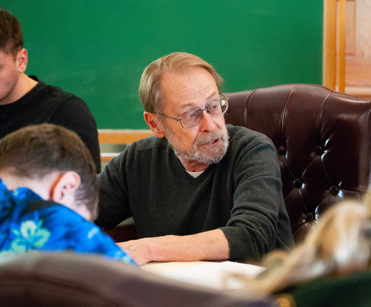 Political Science professor sitting with students and giving a lecture