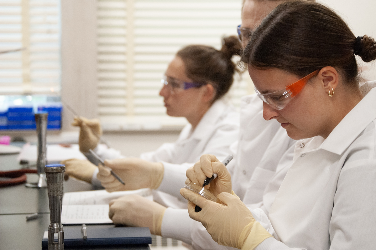 student labeling petri dish in science lab
