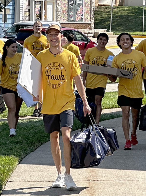 student carrying in luggage on freshman move in day