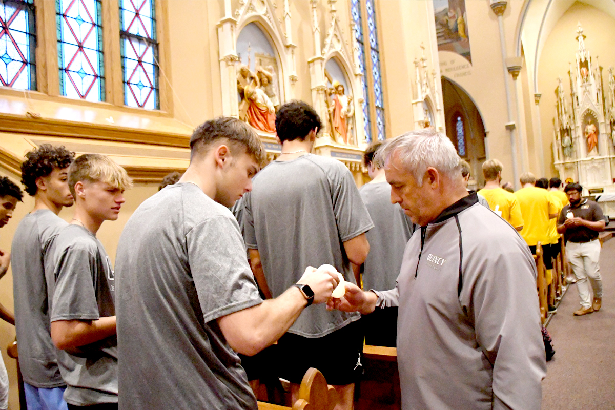 Blessing of the Athletes ceremony with a coach lighting the candle of a player