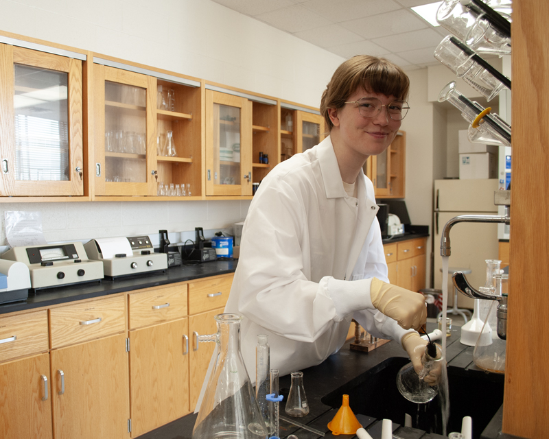 Biology student cleaning science equipment in the lab