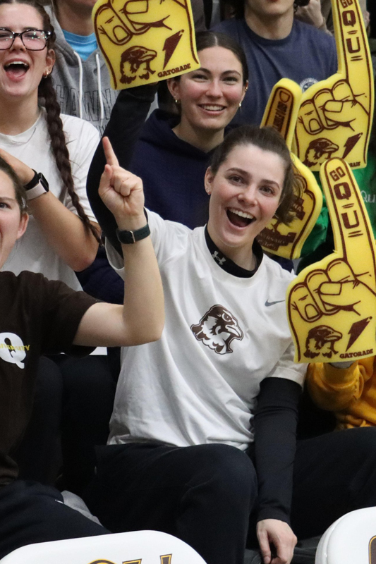 QU fans at a basketball game with foam fingers