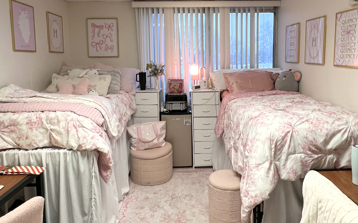 interior of dorm room with two twin beds with pink & white comforters