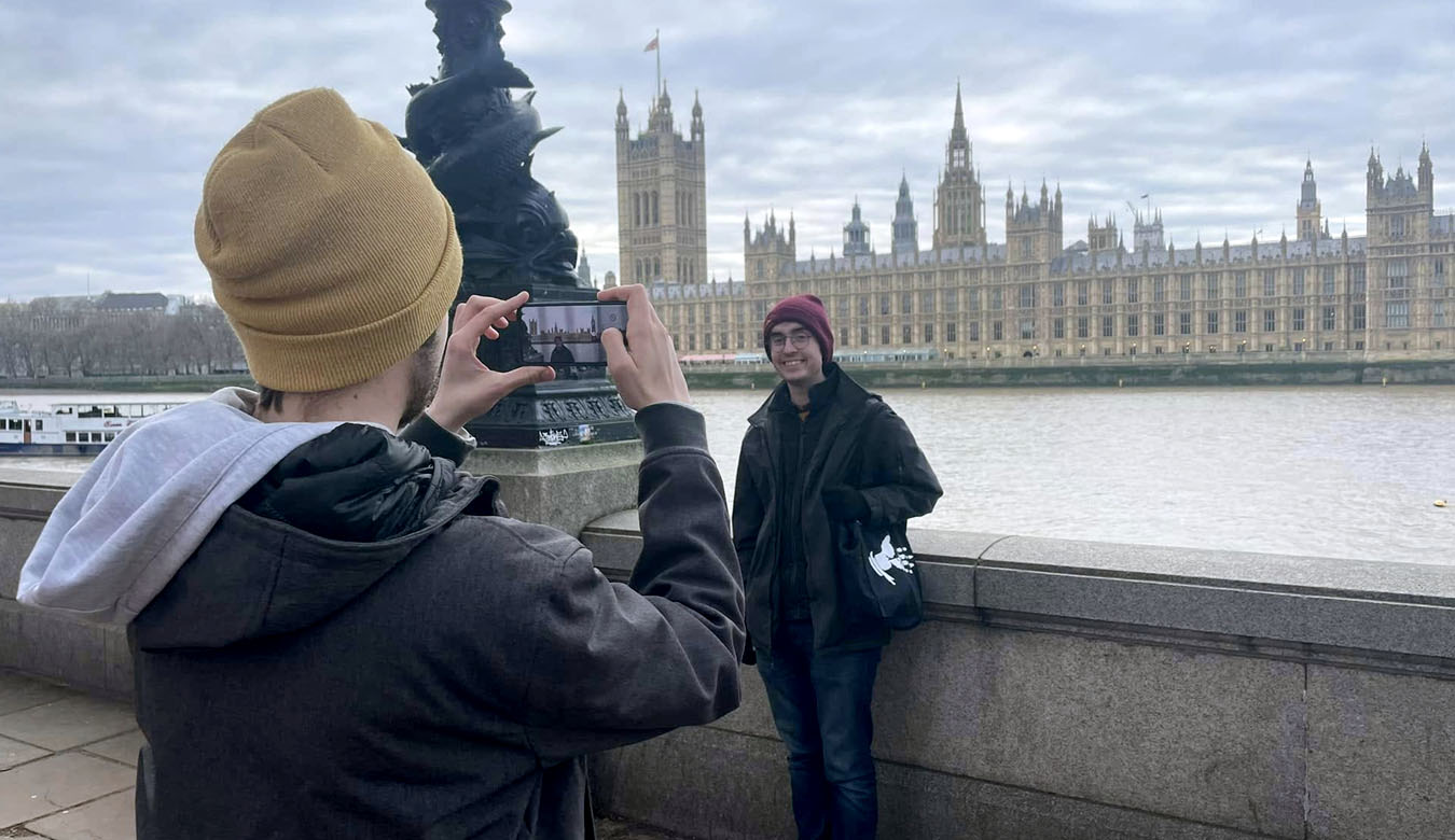 students taking photo near river in London