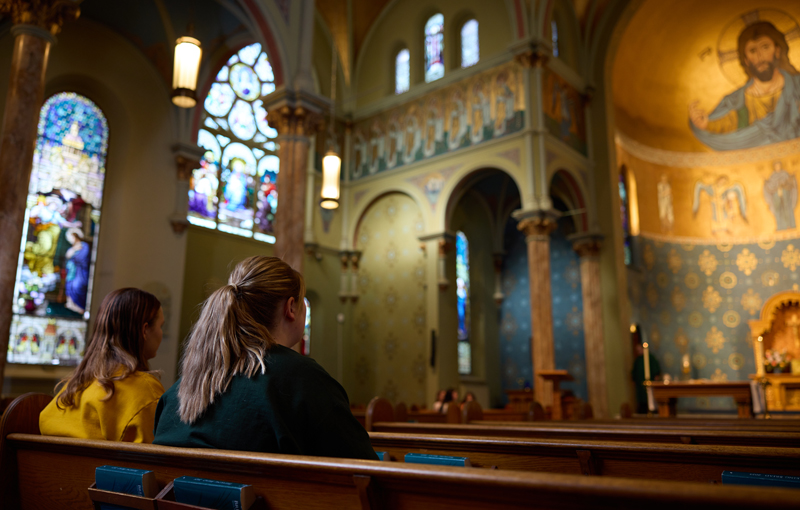 two students praying in chapel