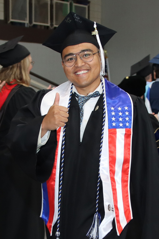 Male graduate giving thumbs up