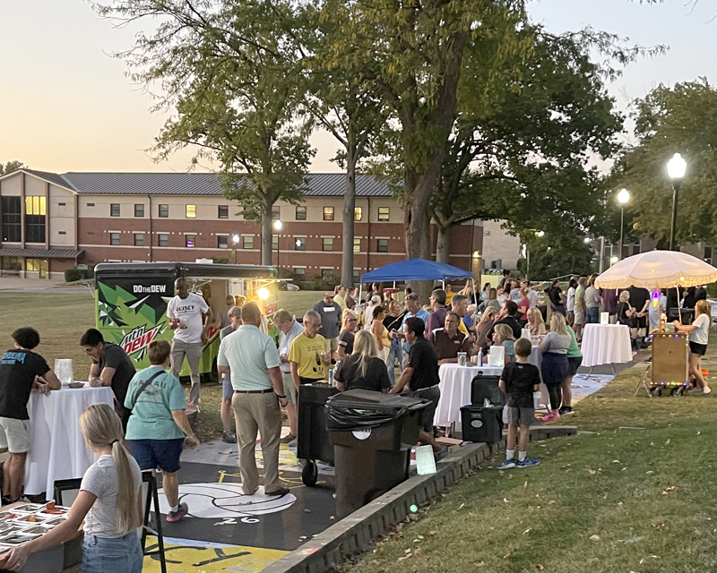 alumni on penny lane at dusk with vendors