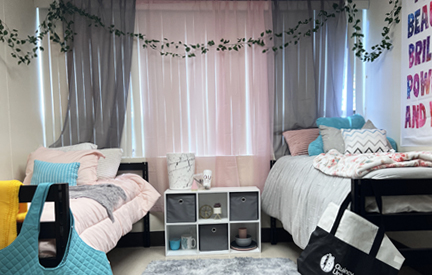 dorm woom with two beds next to window with pink and white comforters