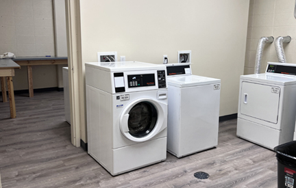 dorm washer and dryer and table for folding behind it in another room