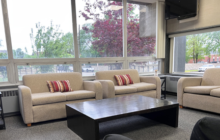 Padua hall common area with two couches near a window.